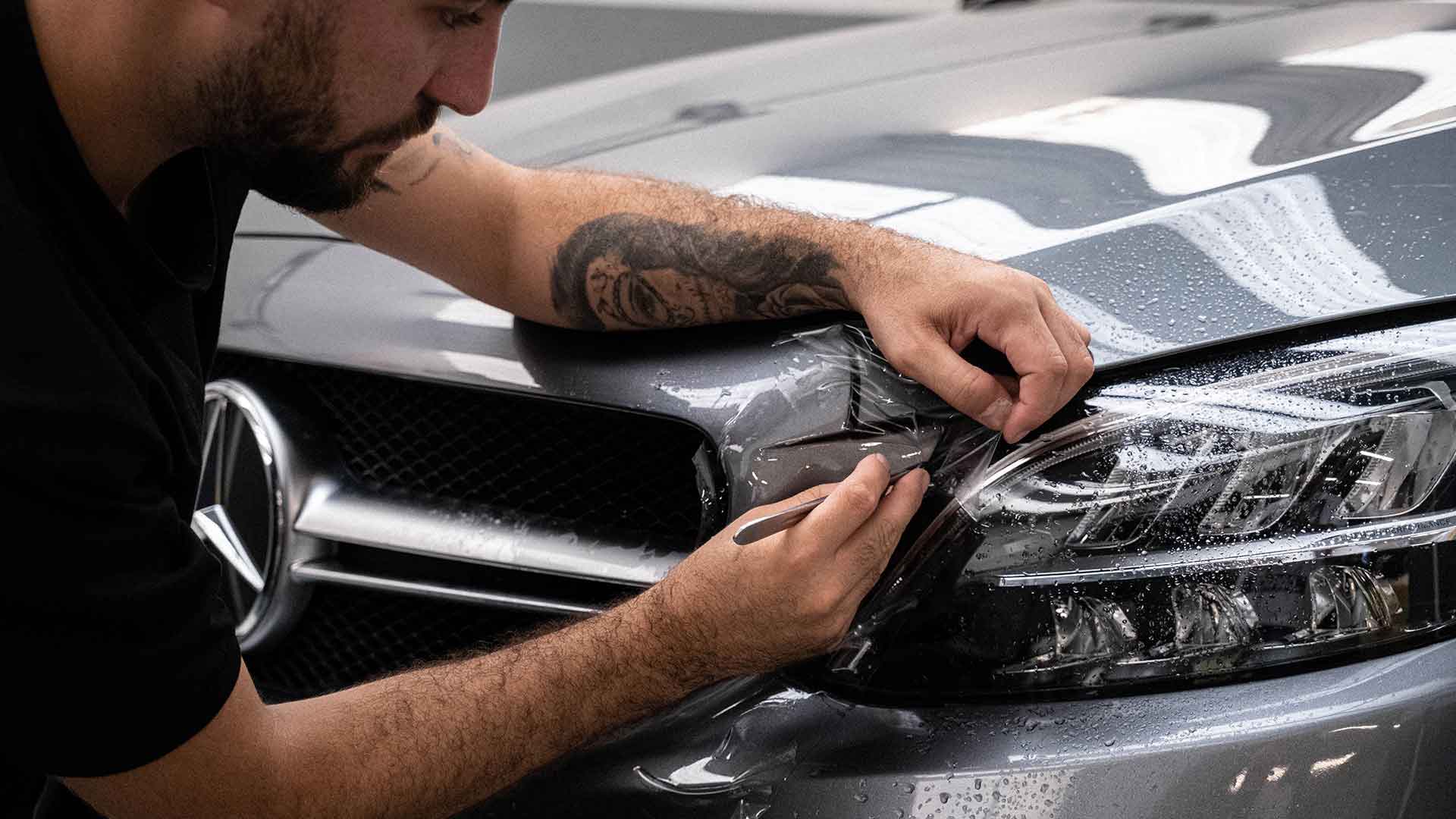 Man applying PPF over Headlights