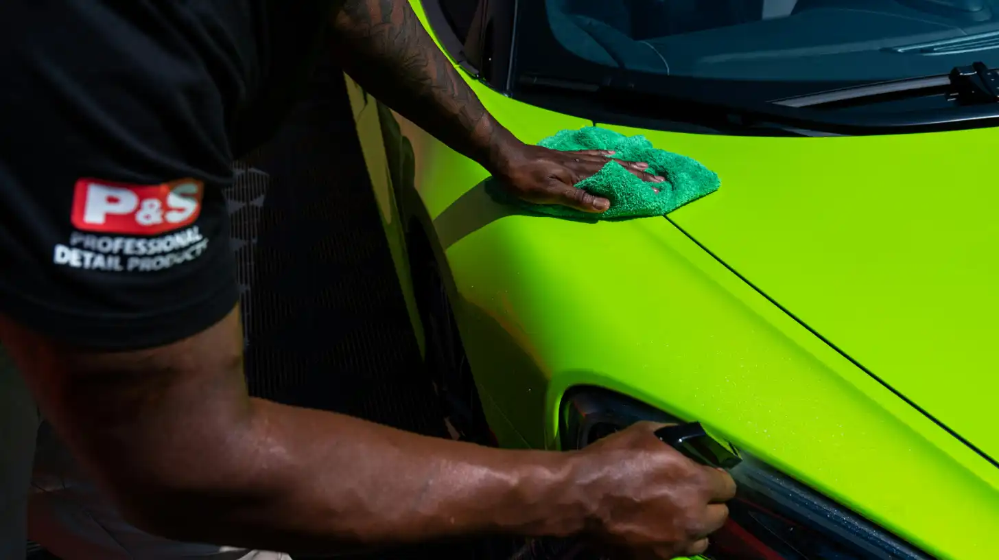 Man cleaning quarter panel on car